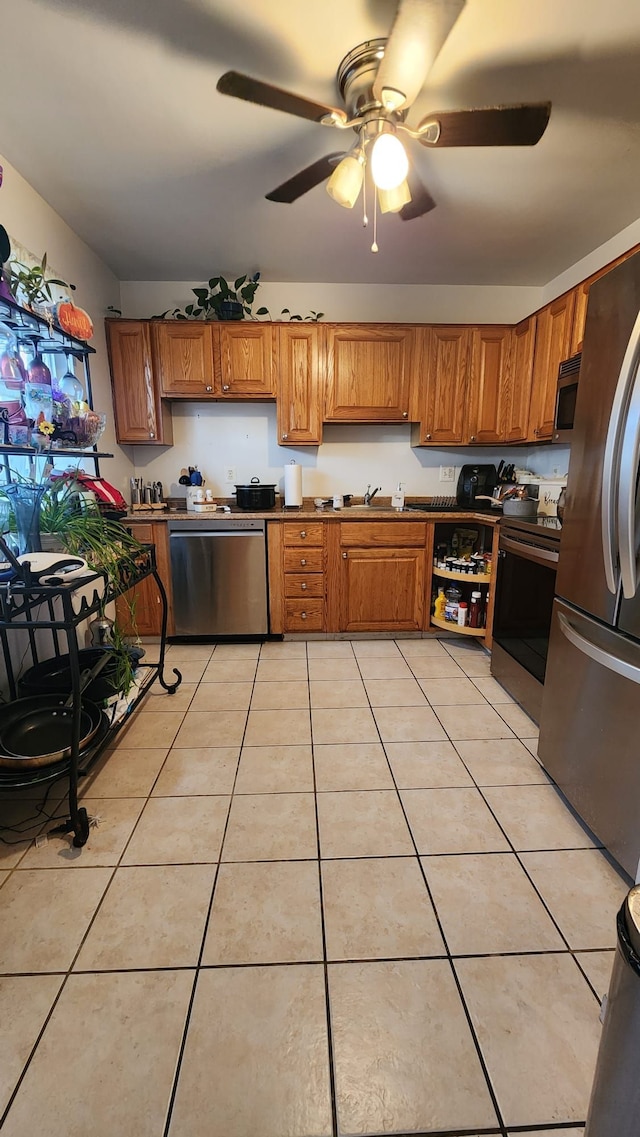 kitchen with ceiling fan, sink, light tile patterned floors, and stainless steel appliances