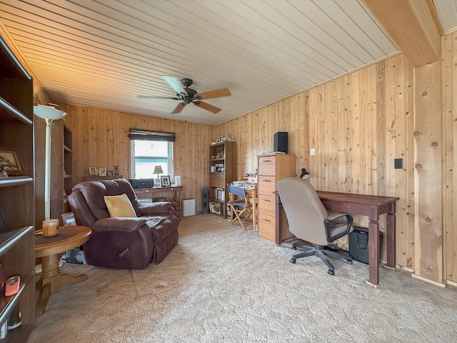 office featuring light carpet, ceiling fan, and wood walls