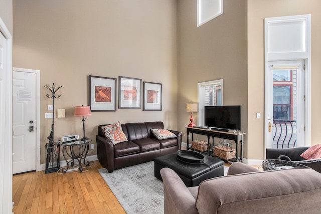 living room featuring a high ceiling and light hardwood / wood-style flooring