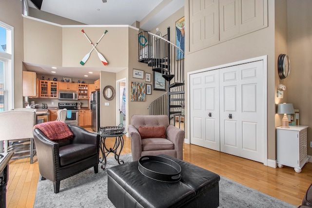 living room featuring light hardwood / wood-style floors, sink, and a high ceiling