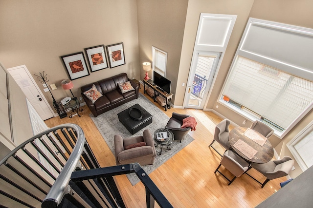 living room featuring a high ceiling and light hardwood / wood-style floors