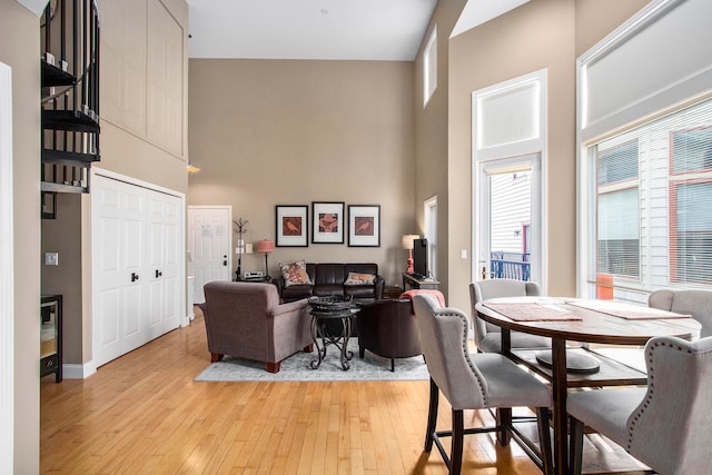 living room with a high ceiling and light hardwood / wood-style flooring