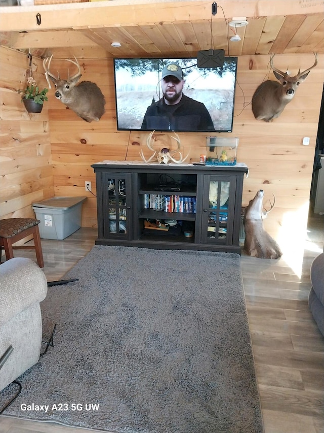 living room with wooden walls, hardwood / wood-style floors, and wood ceiling