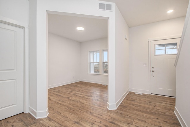 foyer entrance featuring visible vents, baseboards, wood finished floors, and recessed lighting