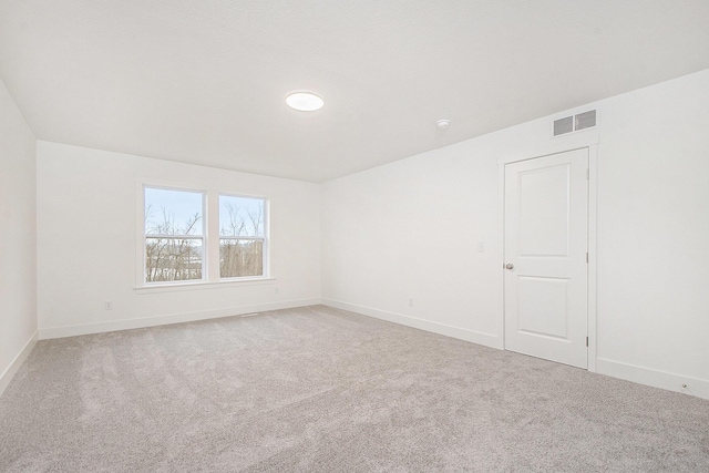 spare room with light carpet, visible vents, and baseboards