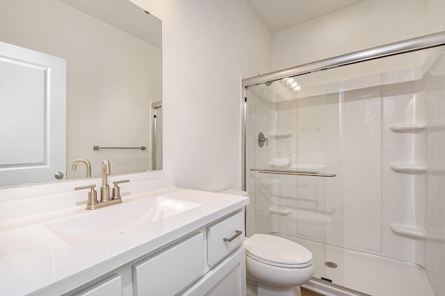 bathroom featuring a stall shower, vanity, and toilet
