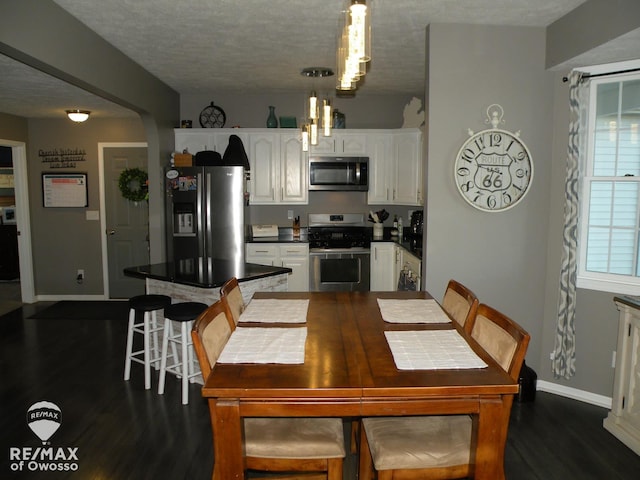 dining area with a textured ceiling and dark hardwood / wood-style floors