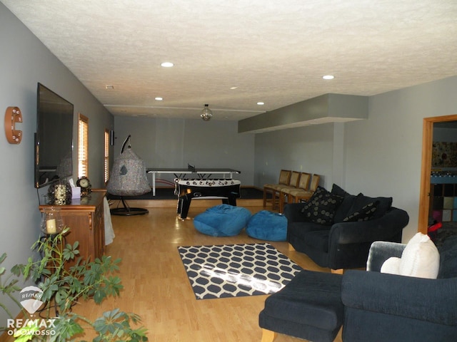 rec room featuring a textured ceiling and light wood-type flooring