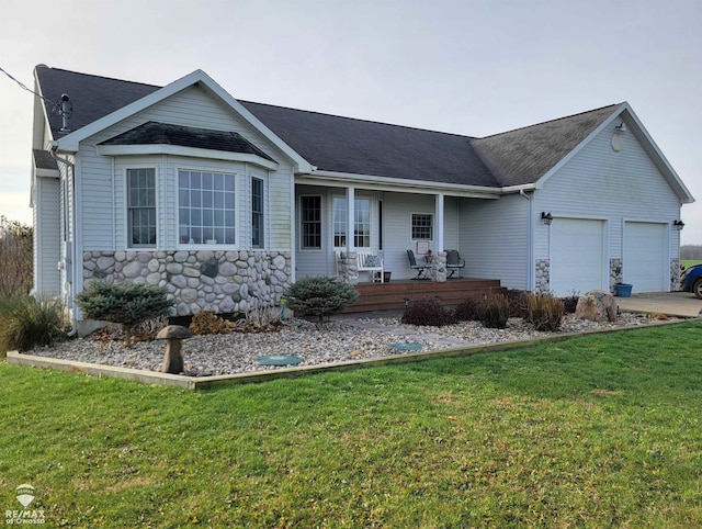 ranch-style house featuring covered porch, a garage, and a front yard