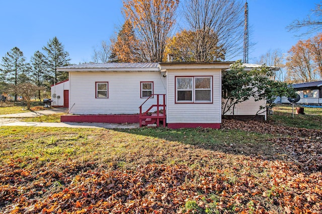 rear view of property featuring a yard