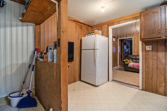 kitchen with white refrigerator and wooden walls