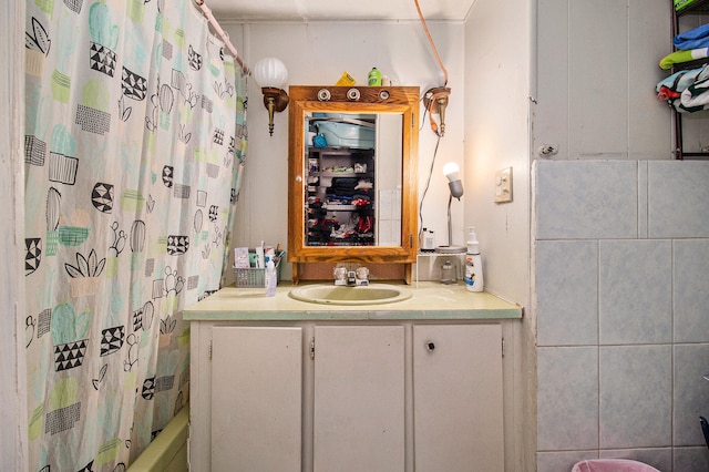 bathroom with tile walls, vanity, and shower / bath combo