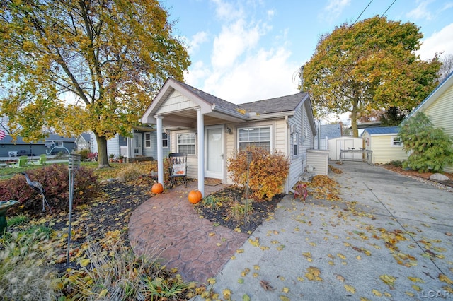 view of front of home with a porch and a storage unit