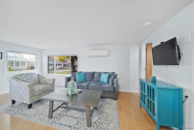 living room with a wall mounted air conditioner and light wood-type flooring