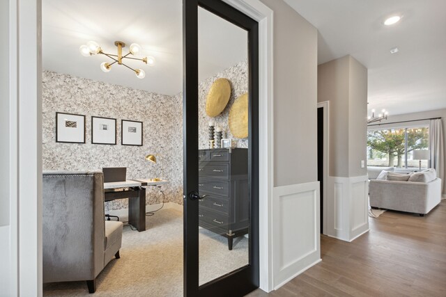 office area with hardwood / wood-style flooring and an inviting chandelier