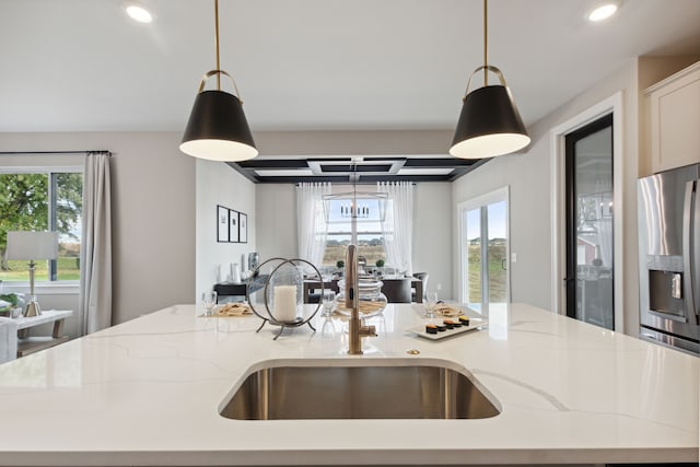 kitchen featuring a center island with sink, plenty of natural light, stainless steel refrigerator with ice dispenser, and a sink