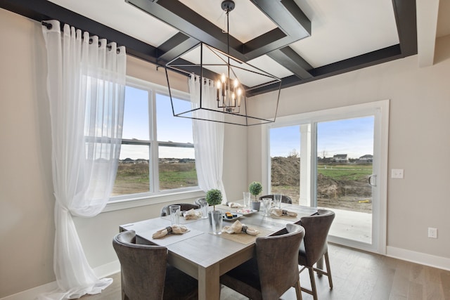 dining space featuring plenty of natural light, coffered ceiling, light wood-type flooring, and baseboards