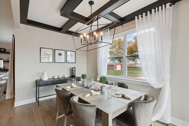 dining area with beamed ceiling, dark wood-type flooring, a healthy amount of sunlight, and a notable chandelier