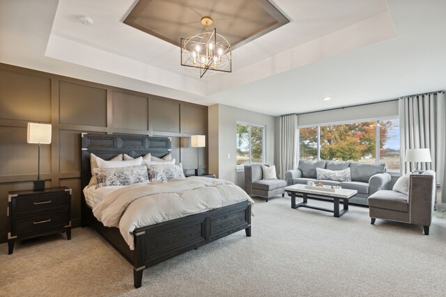 carpeted bedroom featuring a raised ceiling and a notable chandelier