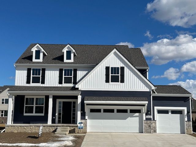 view of front of property featuring driveway, roof with shingles, a porch, an attached garage, and board and batten siding