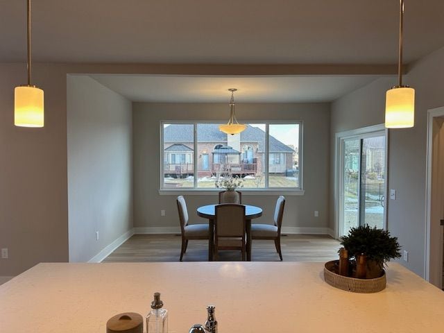 dining area featuring light wood finished floors and baseboards