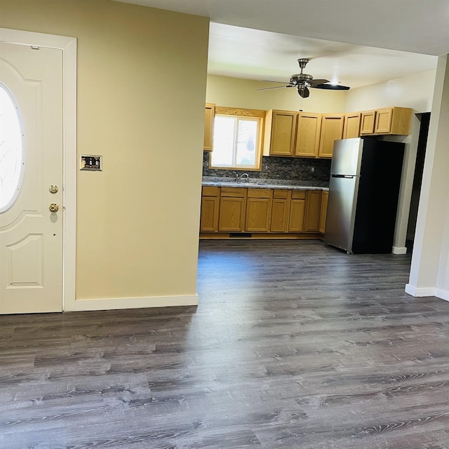 kitchen featuring stainless steel fridge, dark hardwood / wood-style flooring, and decorative backsplash