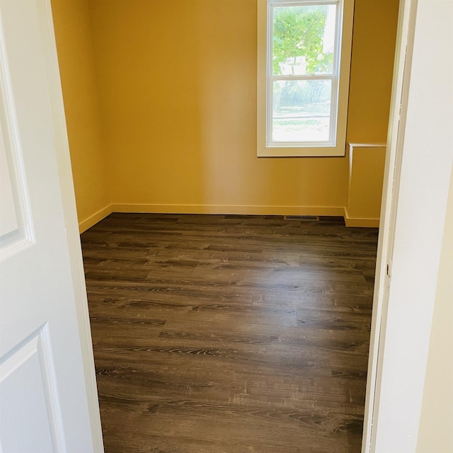 spare room with dark wood-type flooring