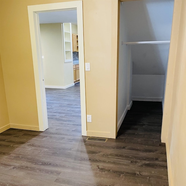 corridor with dark hardwood / wood-style flooring