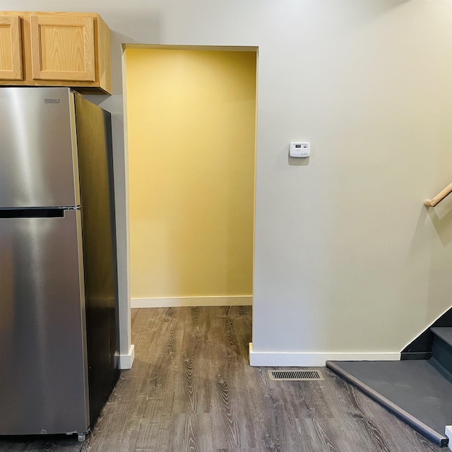 kitchen with stainless steel refrigerator, dark hardwood / wood-style floors, and light brown cabinetry