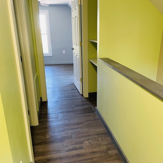 hallway with vaulted ceiling and dark hardwood / wood-style flooring