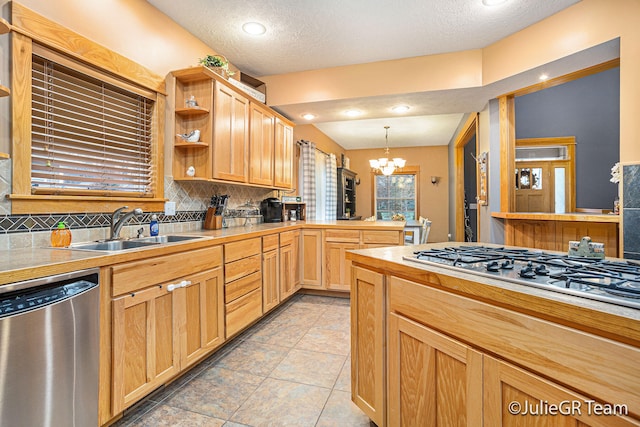 kitchen with sink, pendant lighting, a textured ceiling, decorative backsplash, and appliances with stainless steel finishes