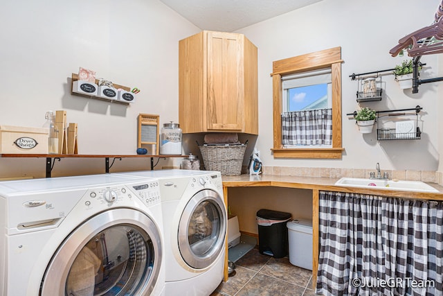 laundry room featuring cabinets, a textured ceiling, sink, dark tile patterned flooring, and independent washer and dryer