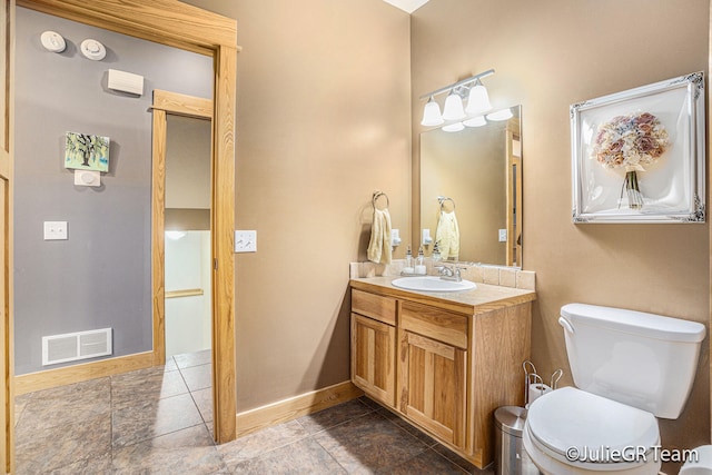 bathroom featuring tile patterned flooring, vanity, and toilet