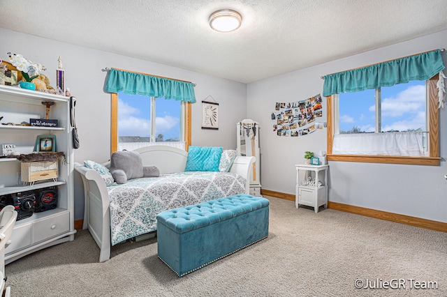 carpeted bedroom with multiple windows and a textured ceiling