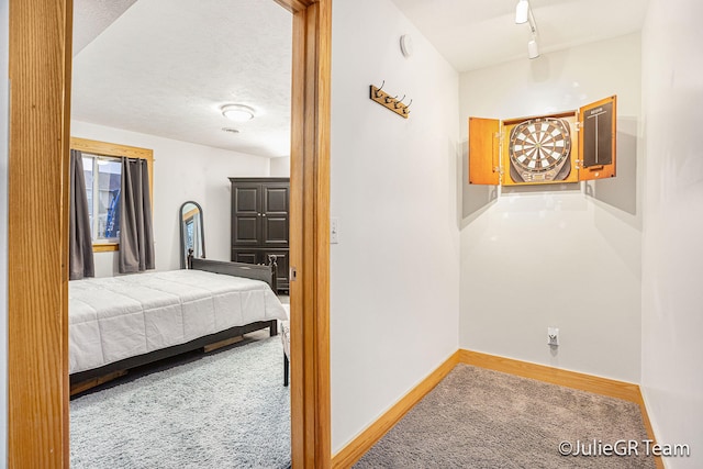 hall with carpet flooring and a textured ceiling