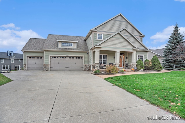 craftsman-style home featuring covered porch, a garage, and a front yard