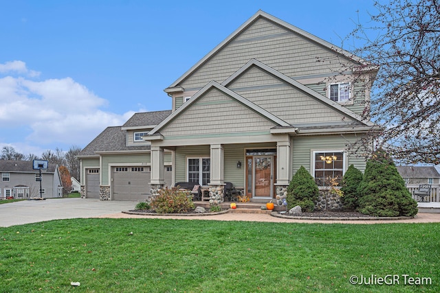 craftsman house featuring a front lawn, covered porch, and a garage