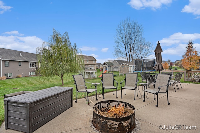 view of patio / terrace featuring a trampoline and an outdoor fire pit