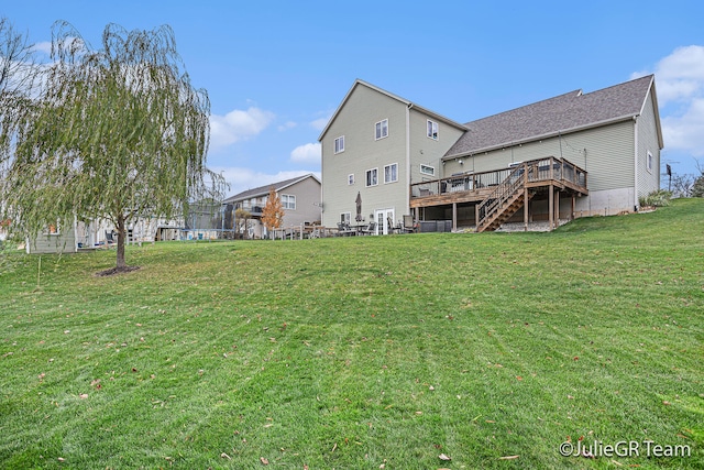 rear view of property featuring a yard and a deck