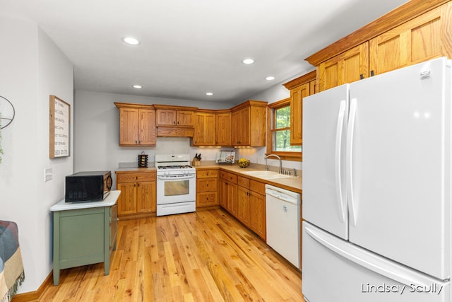 kitchen featuring white appliances, light hardwood / wood-style flooring, and sink