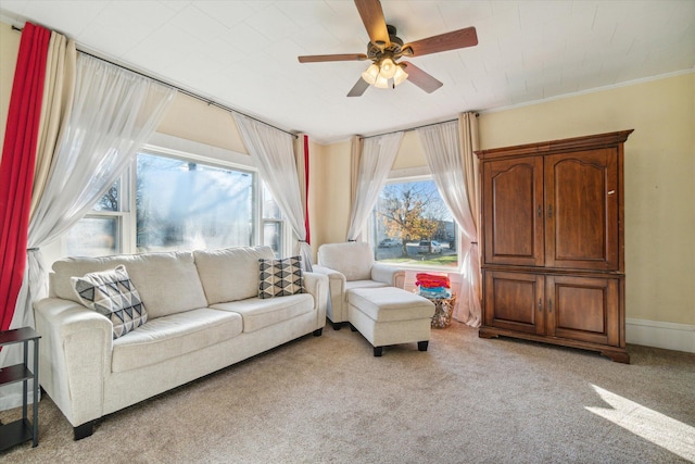 living room with light colored carpet, ceiling fan, and ornamental molding