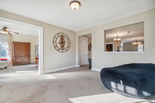 carpeted bedroom featuring ceiling fan with notable chandelier