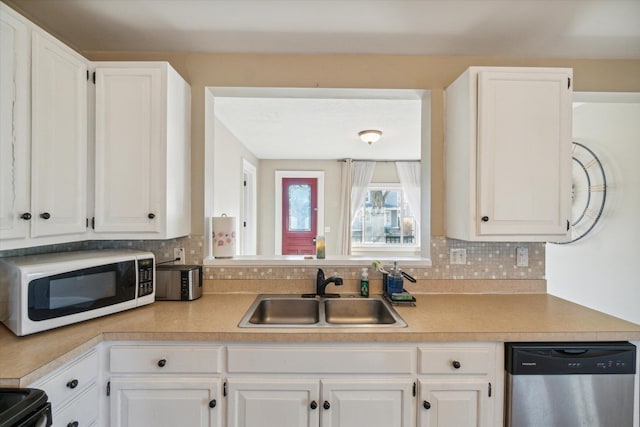 kitchen featuring dishwasher, black range, sink, tasteful backsplash, and white cabinetry