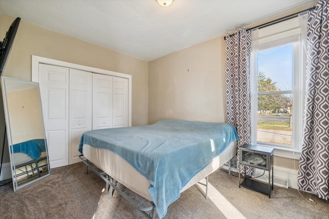 carpeted bedroom with multiple windows and a closet