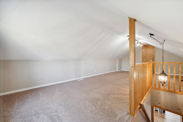 additional living space with carpet floors and vaulted ceiling