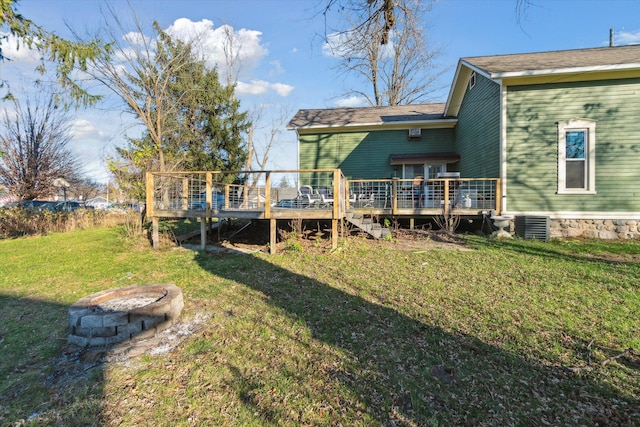 view of yard with central AC, a deck, and an outdoor fire pit