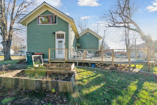 rear view of house featuring a yard and a wooden deck