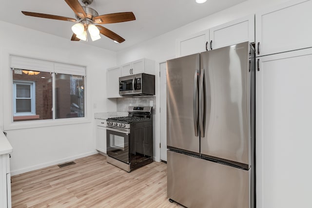 kitchen featuring white cabinets, light hardwood / wood-style flooring, decorative backsplash, ceiling fan, and appliances with stainless steel finishes