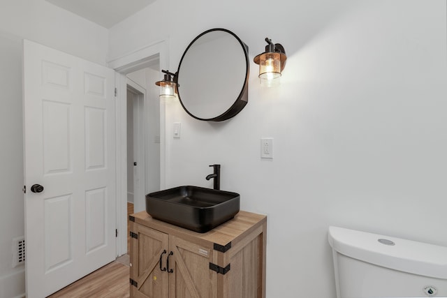 bathroom featuring hardwood / wood-style flooring, vanity, and toilet