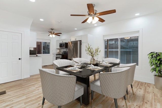 dining space with ceiling fan and light hardwood / wood-style flooring